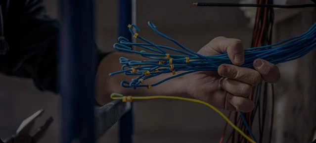Conductores eléctricos con extremos expuestos en las manos de un técnico